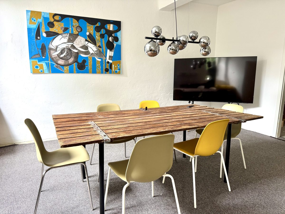 Meetingraum mit großem Bildschirm und Holztisch